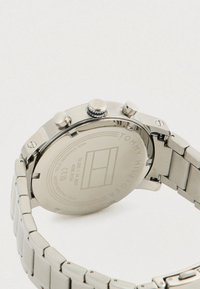 Rozsdamentes acél Tommy Hilfiger karóra hátoldala, amelyen a márkajelzés, a modellszám és a vízállósági adatok láthatók.