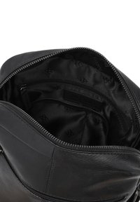 Borsa in pelle nera con apertura con zip, dotata di un morbido interno in tessuto impresso con un logo e una piccola tasca interna per un'ottimizzazione dell'organizzazione.