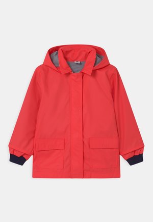 Veste imperméable rouge à capuche avec doublure intérieure rayée, poches à rabat devant et poignets bleu foncé.