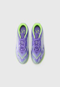 Scarpe da calcio viola e verdi con un design elegante, superficie texturizzata e strisce bianche diagonali. Lacci dello stesso colore viola.