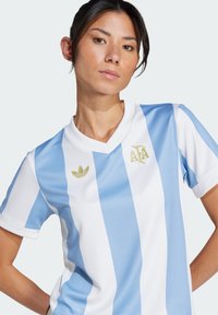Gaiši zils un balts svītrots futbola krekls ar V veida kaklu. Iekļauj zelta Adidas logo un ģērboni, izgatavots no elpojoša auduma.