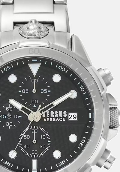 Orologio in acciaio inossidabile argentato con quadrante nero testurizzato. Le caratteristiche includono tre sottodial, lancette luminescenti e una finestra per la data. Logo Versus visibile.