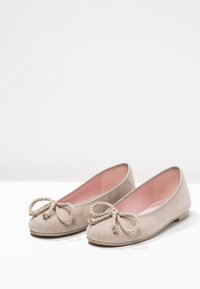 Beige suede balletflade med en rund tå og snor-bue detalje foran. Indersiden har pink foring. Flad sål for komfortabel brug.
