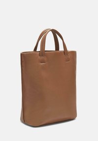 Brązowa skórzana torba tote z dwoma krótkimi uchwytami, prostokątnym kształtem, gładką fakturą i minimalną ilością szwów. Brak widocznych elementów metalowych lub akcentów.