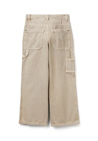 Béžové široké kalhoty s poutky na pásek, zadními nášivkovými kapsami, boční kapsou na nářadí a páskovou smyčkou na kladivo, vyrobené z pevné džínové látky.