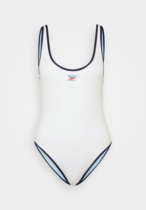 Bijeli jednodijelni kupaći kostim s tamnoplavim i svijetloplavim detaljima, s tankim naramenicama i izrezom vraća. Na prednjoj strani nalazi se "Speedo" logo.