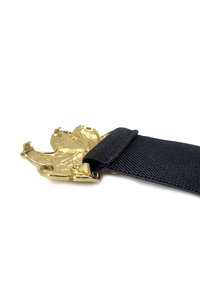 Cintura in tessuto nero con un'attaccatura in metallo dorato caratterizzata da un dettagliato design a artiglio. La texture è intrecciata, aggiungendo profondità all'aspetto.