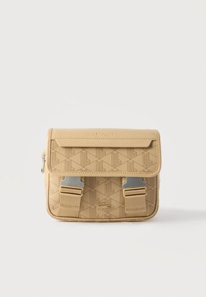Pequeño bolso bandolera beige de Lacoste con patrón geométrico, solapa frontal, hebillas metálicas y logotipo de cocodrilo en relieve.