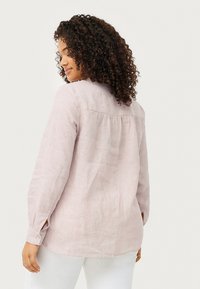 Light pink, long-sleeve shirt in a textured linen fabric, featuring a rounded collar and buttoned cuffs, with a gathered back detail.