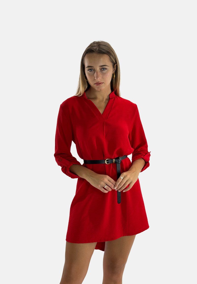 Robe chemise rouge avec col et manches boutonnées, dotée d'une ceinture noire à la taille. Texture douce, longueur genou et coupe décontractée.
