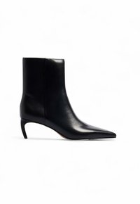 Črne usnjene gležnjarje s koničastim nosom in majhno, vitko peto. Gladka tekstura s sodobnim, minimalističnim oblikovanjem.