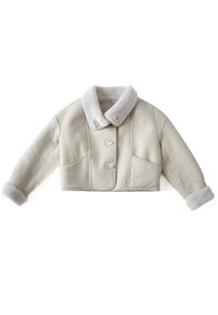 Veste courte en peau lainée beige avec col large, fermeture à boutons, deux poches et poignets doublés de fourrure aux manches longues.