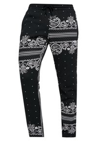Černé kalhoty s pasem na stahovací šňůrku, zdobené bílým paisley vzorem a tečkami. Vyrobené z hladkého materiálu, s úzkým střihem.