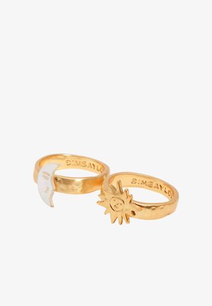 Dve zlati prstani z majhnimi oblikami sonca in polmeseca z obrazi na belem ozadju.