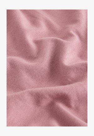 Pehmea, kortsus roosa kangas peene kudumise tekstuuri ja nähtavate kiududega, näidatud lähivõttes.