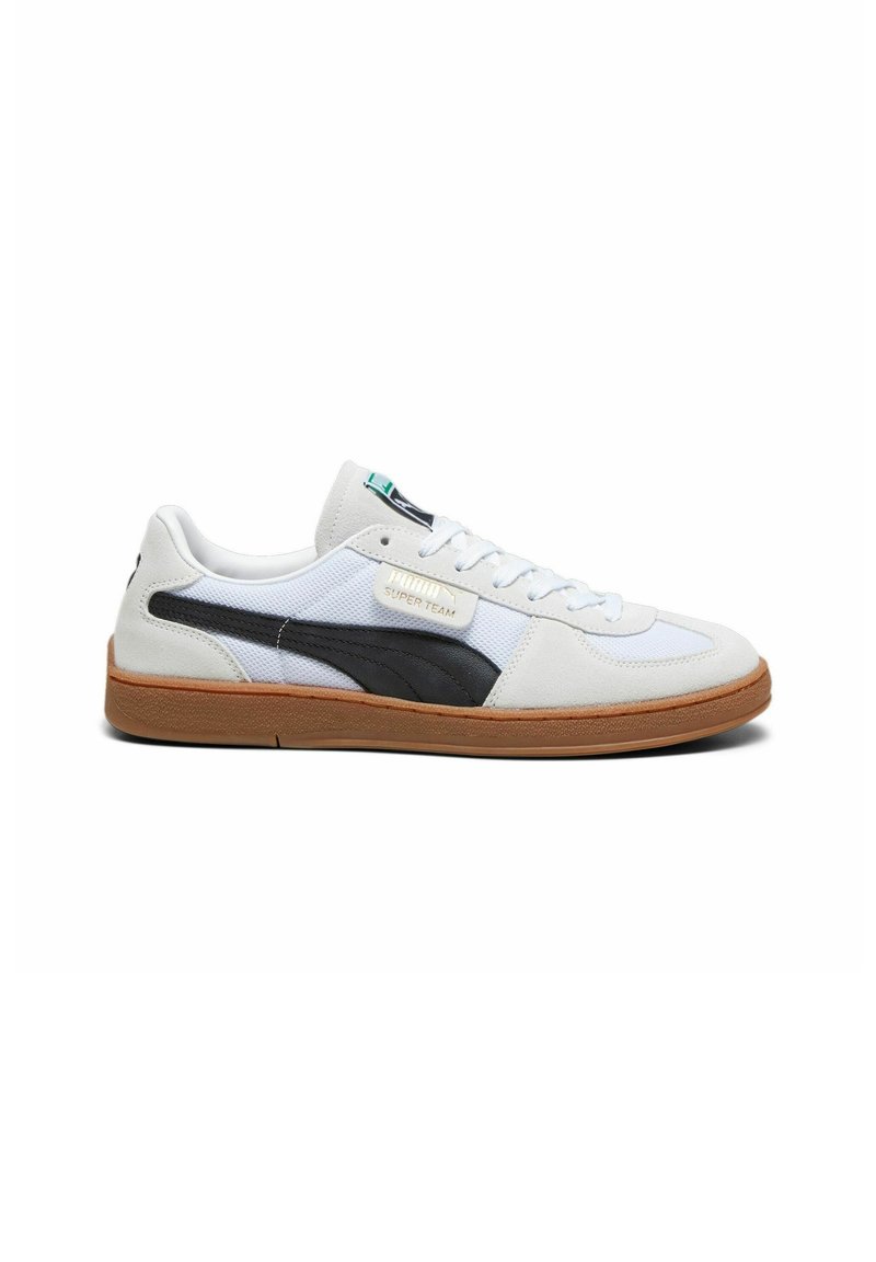 Sneaker bianco e grigio con una striscia nera sul lato, suola in gomma, design con lacci e dettagli del logo sul lato. Materiali testurizzati inclusi.