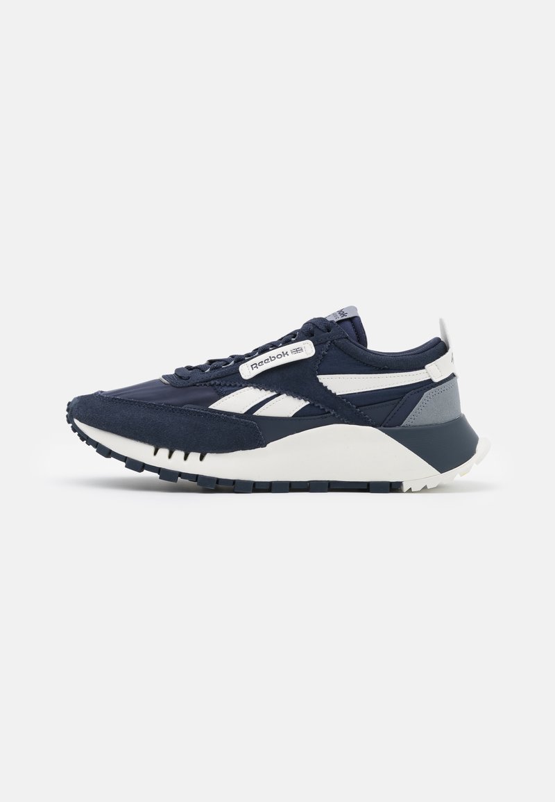 Granatowo-białe buty sportowe Reebok z zamszową i siateczkową cholewką, masywną podeszwą i markowymi detalami na boku i języku.