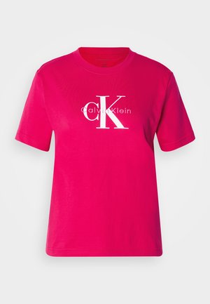 Pink cotton t-shirt with short sleeves, featuring a large white "CK" logo and "Calvin Klein" text in a modern font. Simple straight-cut design.