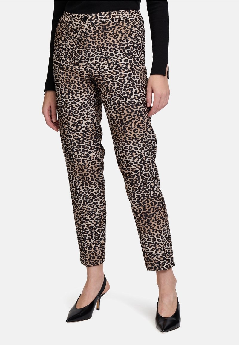 Pantalones de estampado de leopardo en una combinación de colores beige y negro, con un diseño ajustado y una textura de tela suave. Forma de pierna delgada con una cintura de altura media.