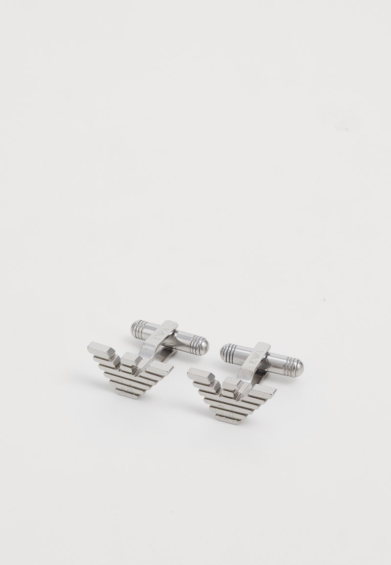 Silver metal cufflinks featuring a geometric, stepped design. Each has a smooth finish and a cylindrical fastening mechanism.