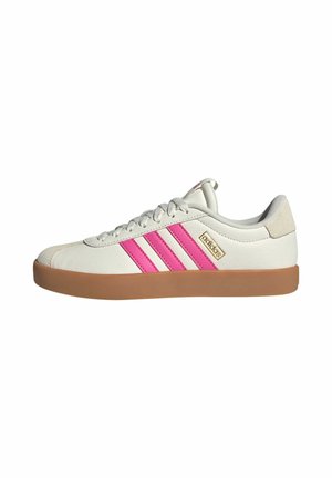 Weiße Adidas-Sneaker in niedrigem Schnitt mit pinkfarbenen Streifen, Gummisohle, Schnürverschluss und goldfarbenem Adidas-Logo an der Seite.