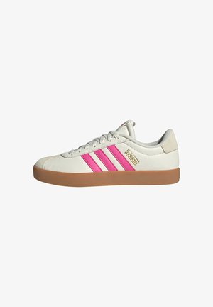 Weiße Adidas-Sneaker in niedrigem Schnitt mit pinkfarbenen Streifen, Gummisohle, Schnürverschluss und goldfarbenem Adidas-Logo an der Seite.