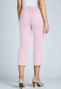 Roze cropped broeken van zachte stof, met een rechte snit en opgerolde zomen, gecombineerd met lichtgrijze hoge hakken.