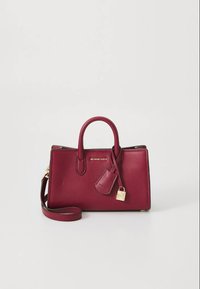 Mala de couro borgonha com duas alças curtas e uma alça de ombro destacável. Apresenta ferragens douradas, um pendente em forma de cadeado e um acabamento texturizado.