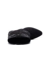 Botín negro de ante con punta afilada, costuras decorativas y una textura suave. Diseño de espalda abierta con un lazo para facilitar el calzado.