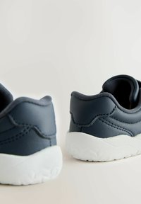 Donkerblauwe sneakers met een gladlederen bovenwerk, witte rubberen zool, afgeronde vorm en verhoogde stikseldetails op de hiel.