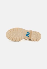 Braune Schuhsohle mit einer dicken, strukturierten Gummibasis. Mit einem blauen "m"-Logo und fünf sternartigen Mustern für besseren Halt.
