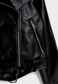 Giacca da motociclista in pelle nera con zip argento, vita con cintura e superficie texturizzata. Presenta tasche con zip inclinate e colletto a revers.