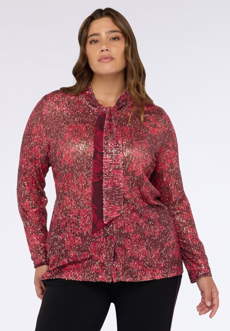 Top a maniche lunghe con un motivo floreale in paillettes in rosa e bordeaux, con scollo a cravatta e tessuto strutturato.