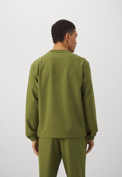 Olive green, long-sleeved pullover with a crew neckline and elastic cuffs, made from a smooth, lightweight fabric. Back view shown.