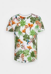Camiseta de manga corta con un vibrante estampado floral y de follaje en verde, naranja y amarillo sobre un fondo blanco. Textura de tela suave.