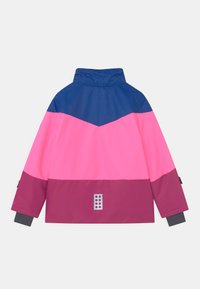 Farbig blockierte Jacke mit einem marineblauen Oberteil, einer pinken Mitte und einem kastanienbraunen unteren Abschnitt. Verfügt über einen hohen Kragen und ein quadratisches Logo auf der Rückseite. Wasserabweisendes Material.