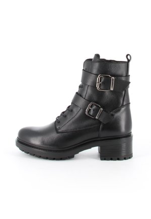 Bottine en cuir noir avec deux boucles argentées, lacets à l'avant, talon épais et semelle crantée sur fond blanc.