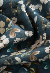 Bloemenstof met een donker teal achtergrond en witte, groene en bruine bloemen. Zachte textuur met een lichte glans en een gevarieerd patroon.