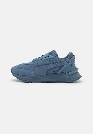 Niebieskie sportowe buty z wiązaniem na sznurówki, teksturowaną tkaniną i nakładkami z zamszu, grubą amortyzowaną podeszwą i markowaną zakładką na pięcie.