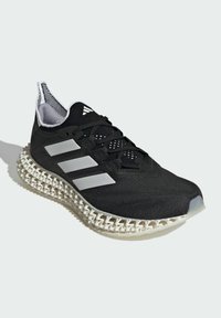 Black athletic shoe with textured mesh upper, three silver stripes, and a unique white lattice midsole design. Features a padded collar.