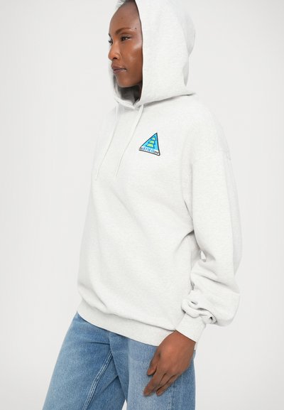 Siva bombažna hoodie z modrim vezenim trikotnim logotipom na prsih, s kapuco na vrvico in ohlapnimi rokavi.
