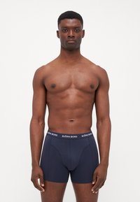 Dark blue boxer briefs made of smooth fabric, featuring a contrasting branded waistband in white with "BJÖRN BORG" text.