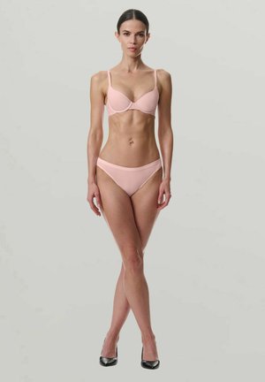Ensemble de lingerie rose clair composé d'un soutien-gorge rembourré et de culottes taille haute assorties. Tissu lisse et extensible avec bretelles fines et design minimaliste.