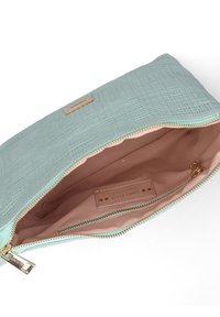 Lichtblauwe, textuurvolle clutch bag met een gouden rits, voorzien van een perzikkleurig interieur en een label aan de binnenkant. Afgemaakt met een gouden hardware label.