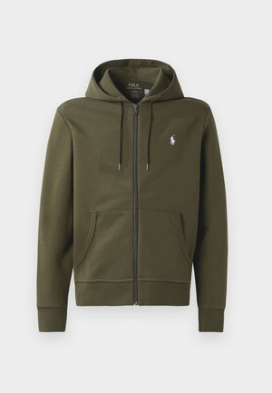 Oliven grønn zip-up hettegenser laget av myk bomull, med kengurulomme, snøring på hetten og en liten hvit logo på venstre bryst.