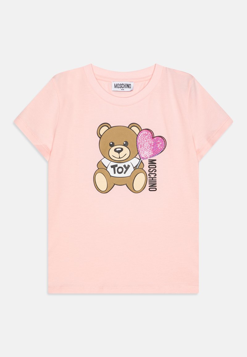 Camiseta de algodón rosa con un dibujo de un oso de caricatura sosteniendo un corazón brillante y el texto "TOY", con cuello redondo y mangas cortas.