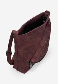 Bolso de hombro burdeos hecho de cuero sintético texturizado, con tachuelas plateadas en un lado y cierre de cremallera en la parte superior. Correa ajustable incluida.