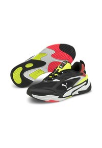 Chaussures de sport noires avec des accents jaunes, rouges et blancs. Elles présentent une tige synthétique lisse, une semelle extérieure texturée et un marquage bien visible.