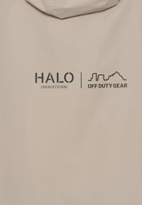 Beige jakke med hætte, der har sorte tekstlogoer: "HALO 196819721981" og "OFF DUTY GEAR" på bagsiden. Glat, mat finish.