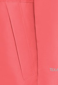 Giacca rosa corallo con texture liscia, dotata di una tasca laterale e cuciture a contrasto. Logo "TEXAS" in azzurro sulla parte anteriore.